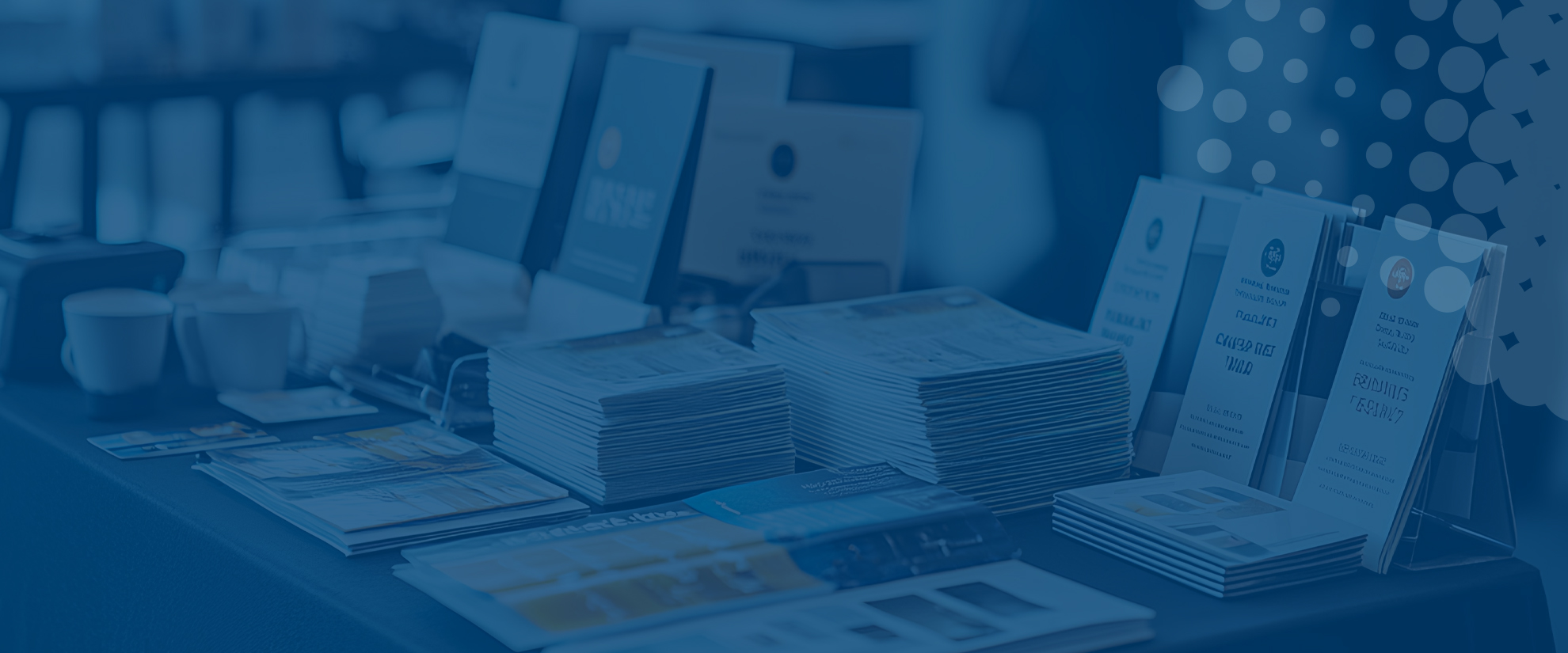 selection of brochures and leaflets on a desk on blue background