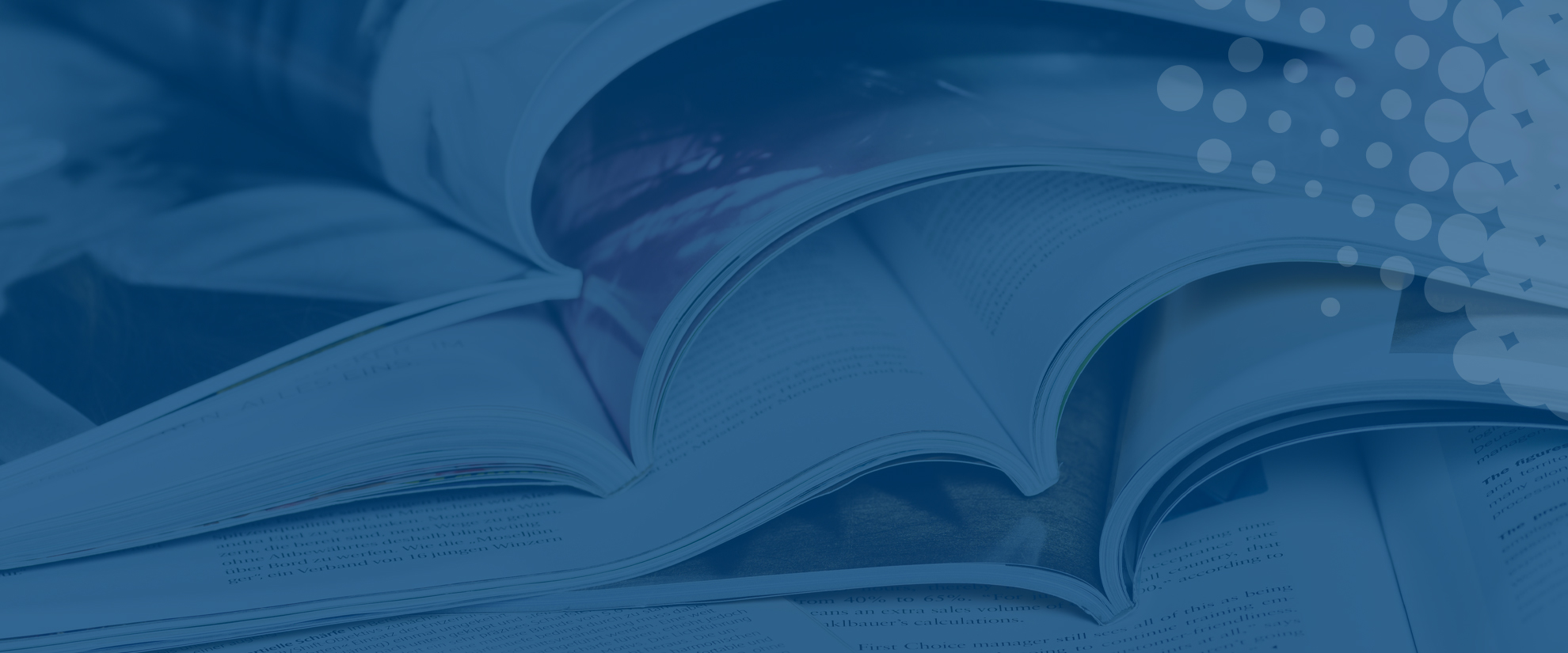 printed magazines open on a desk on blue background